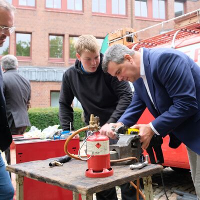 Bild vergr&ouml;&szlig;ern: Das Bild zwei M�nner, die an einer Maschine arbeiten.