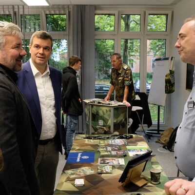 Bild vergr&ouml;&szlig;ern: Das Bild zeigt mehrere M�nner, die sich unterhalten.
