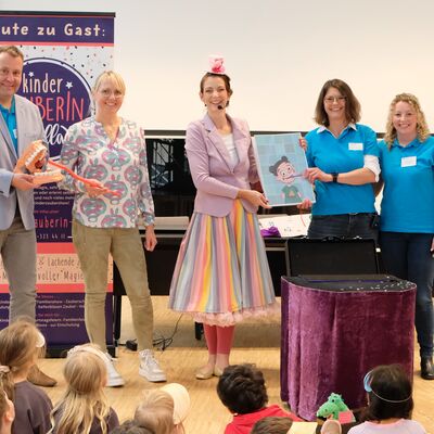 Bild vergr&ouml;&szlig;ern: Die Show von Kinderzauberin Jella (Mitte) kommt nicht nur bei den Kindern, sondern auch bei Martin Bunzel (Fachdienstleiter Verwaltung, Fachbereich Gesundheit und Verbraucherschutz), Schirmherrin Dr. Anke Gabriel sowie Isabelle Seifert und Nadine Koczy von der Aktionsgemeinschaft "Gesunde Z�hne" (von links) gut an.
