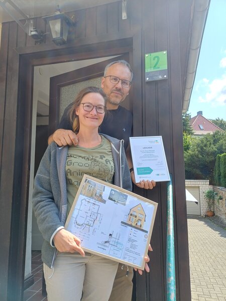 Bild vergr&ouml;&szlig;ern: Das Bild zeigt einen Mann und eine Frau, die vor ihrem Haus stehen.