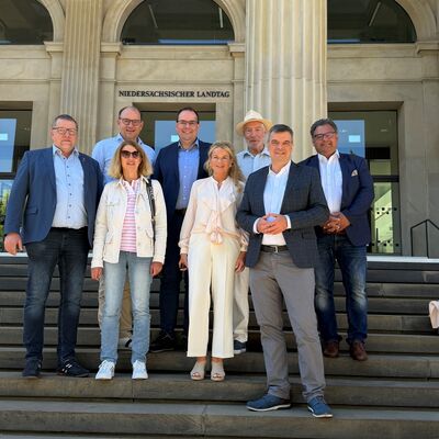 Bild vergr&ouml;&szlig;ern: Das Bild zeigt Menschen, die auf einer Treppe stehen.