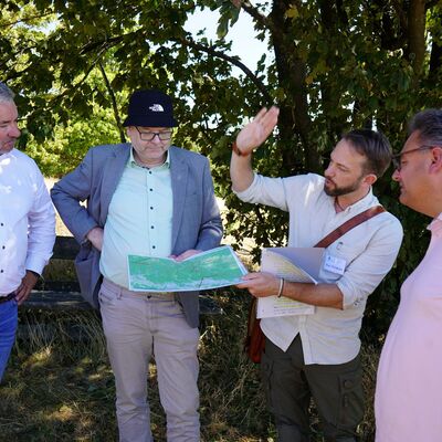 Bild vergr&ouml;&szlig;ern: Das Bild zeit 4 M�nner, die auf eine Karte schauen.