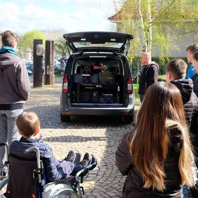 Bild vergr&ouml;&szlig;ern: Junge Leute stehen im Kreis und h�ren einem Vortrag zu.